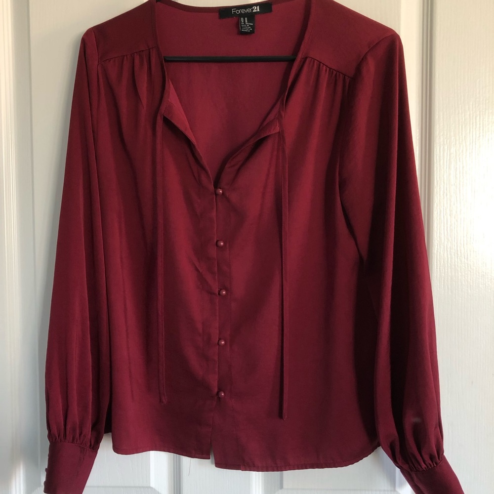Burgundy silk blouse with button details.